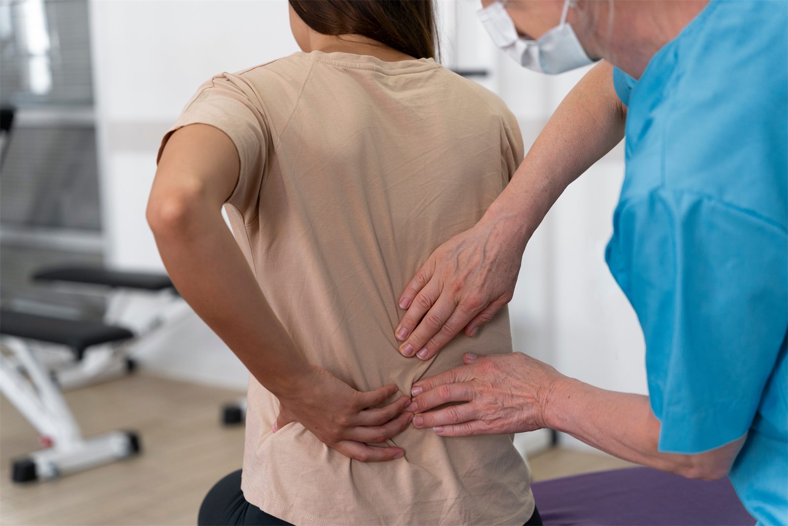 Chiropractor assessing a patient's lower back